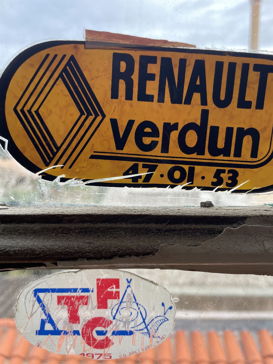 Anciens autocollants des années 1970 collés sur le vitrage d’une fenêtre de la villa
