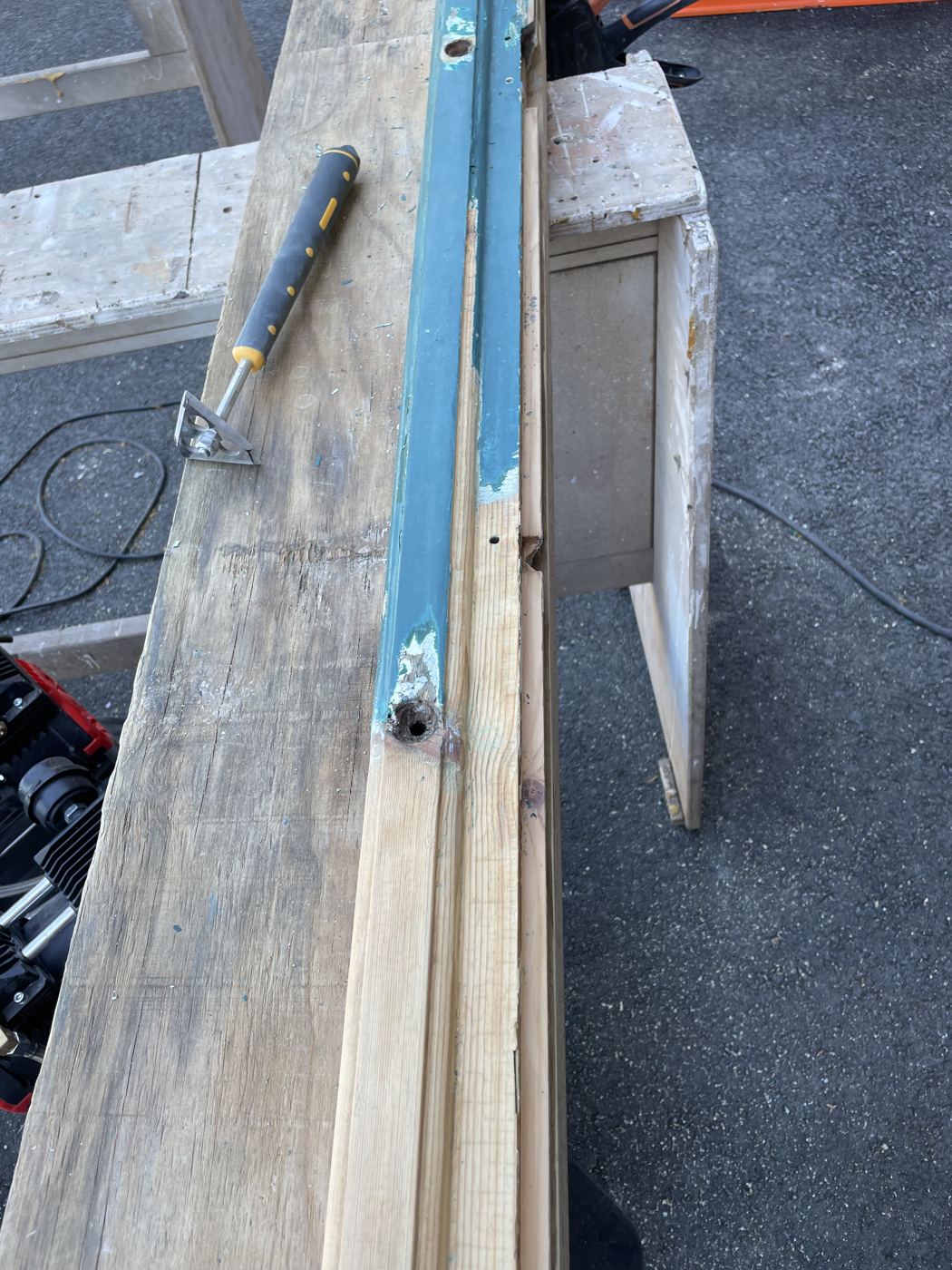 Ponçage en cours d’un montant de fenêtre ancienne à l’atelier
